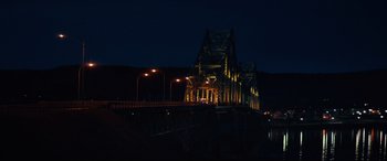 Movie still from “Blood Quantum” (2019), directed by Jeff Barnaby – A night view of a bridge with lights on it; Extreme Wide shot, Low angle