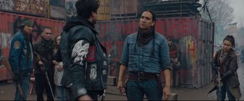 Movie still from “Blood Quantum” (2019), directed by Jeff Barnaby – Two men standing next to each other in front of a building; Medium shot, Over the shoulder angle