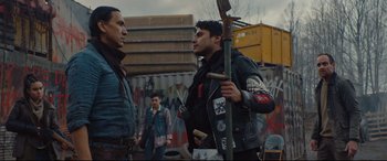 Movie still from “Blood Quantum” (2019), directed by Jeff Barnaby – A group of men standing next to each other on a street; Medium shot, Over the shoulder angle