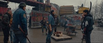 Movie still from “Blood Quantum” (2019), directed by Jeff Barnaby – A group of people standing around a dead body; Wide shot, Over the shoulder angle