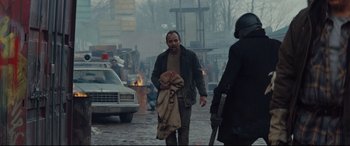 Movie still from “Blood Quantum” (2019), directed by Jeff Barnaby – A man walking down the street with a blanket; Medium shot, Over the shoulder angle