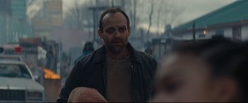 Movie still from “Blood Quantum” (2019), directed by Jeff Barnaby – A man in a black jacket is looking at the camera; Close Up shot, Over the shoulder angle