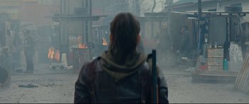 Movie still from “Blood Quantum” (2019), directed by Jeff Barnaby – A man in a leather jacket is standing in front of a fire pit; Wide shot, Over the shoulder angle