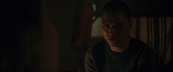Movie still from “Blood Quantum” (2019), directed by Jeff Barnaby – A man in a dark room looking at the camera; Close Up shot, Low angle