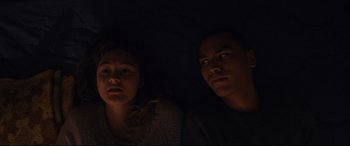 Movie still from “Blood Quantum” (2019), directed by Jeff Barnaby – A man and a woman laying in a dark room; Medium shot, Overhead angle