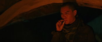 Movie still from “Blood Quantum” (2019), directed by Jeff Barnaby – A man is smoking a cigarette in a dark room; Close Up shot, Low angle