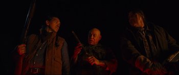 Movie still from “Blood Quantum” (2019), directed by Jeff Barnaby – A man holding a sword in his hand while another man looks on; Medium shot, Low angle