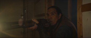Movie still from “Blood Quantum” (2019), directed by Jeff Barnaby – A man holding something up to his face; Medium shot, Over the shoulder angle