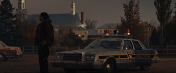 Movie still from “Blood Quantum” (2019), directed by Jeff Barnaby – An old police car parked on the side of the road; Wide shot, Low angle