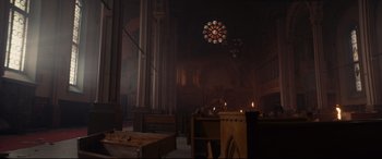 Movie still from “Blood Quantum” (2019), directed by Jeff Barnaby – A church has a stained glass window and candles in it; Extreme Wide shot, High angle