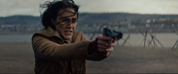 Movie still from “Blood Quantum” (2019), directed by Jeff Barnaby – A woman is holding a gun and pointing it; Close Up shot, Over the shoulder angle