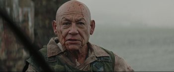 Movie still from “Blood Quantum” (2019), directed by Jeff Barnaby – An old man with a bald head with blood all over his face; Close Up shot, Over the shoulder angle