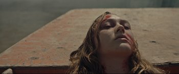 Movie still from “Blood Quantum” (2019), directed by Jeff Barnaby – A woman with a head wound laying on the ground; Close Up shot, Overhead angle