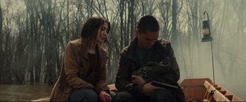 Movie still from “Blood Quantum” (2019), directed by Jeff Barnaby – A man and a woman sitting next to each other on a bench; Medium shot, Over the shoulder angle