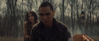 Movie still from “Blood Quantum” (2019), directed by Jeff Barnaby – A man and a woman standing next to each other in front of trees; Close Up shot, Over the shoulder angle