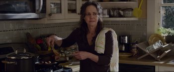 Movie still from “The Amazing Spider-Man” (2012), directed by Marc Webb – A woman in a kitchen with a towel around her neck; Close Up shot, Over the shoulder angle