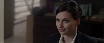 Movie still from “The Amazing Spider-Man” (2012), directed by Marc Webb – A woman wearing a suit and tie with a headset on; Close Up shot, Over the shoulder angle