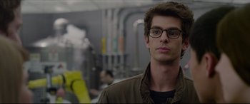 Movie still from “The Amazing Spider-Man” (2012), directed by Marc Webb – A man wearing glasses standing in a room; Close Up shot, Over the shoulder angle