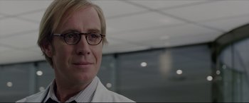 Movie still from “The Amazing Spider-Man” (2012), directed by Marc Webb – A person wearing glasses and a lab coat; Close Up shot, Over the shoulder angle