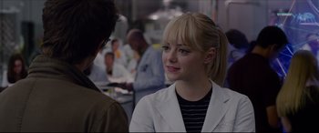 Movie still from “The Amazing Spider-Man” (2012), directed by Marc Webb – A woman wearing a white lab coat is smiling; Close Up shot, Over the shoulder angle