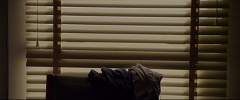 Movie still from “The Amazing Spider-Man” (2012), directed by Marc Webb – A black shirt and a brown shirt on a couch; Medium shot, Low angle