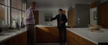 Movie still from “The Amazing Spider-Man” (2012), directed by Marc Webb – Two men standing in a kitchen one of which is holding a coffee pot; Wide shot, Over the shoulder angle