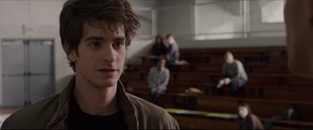 Movie still from “The Amazing Spider-Man” (2012), directed by Marc Webb – A young man standing in front of a group of people; Close Up shot, Over the shoulder angle