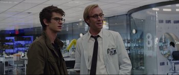 Movie still from “The Amazing Spider-Man” (2012), directed by Marc Webb – A man in a lab coat standing next to another man; Medium shot, Over the shoulder angle