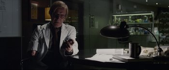 Movie still from “The Amazing Spider-Man” (2012), directed by Marc Webb – A man in a white lab coat holding a pen; Medium shot, Low angle