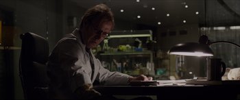 Movie still from “The Amazing Spider-Man” (2012), directed by Marc Webb – A man sitting at a table in front of a laptop computer; Medium shot, Low angle