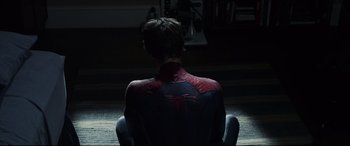 Movie still from “The Amazing Spider-Man” (2012), directed by Marc Webb – A man sitting in a chair with his back to the camera; Medium shot, High angle