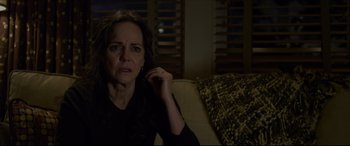 Movie still from “The Amazing Spider-Man” (2012), directed by Marc Webb – An older woman sitting on a couch in a dark room; Close Up shot, Over the shoulder angle