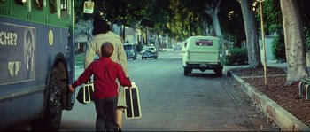 Movie still from “Blow” (2001), directed by Ted Demme – A woman and a boy walking down a street; Wide shot, Over the shoulder angle