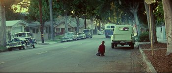 Movie still from “Blow” (2001), directed by Ted Demme – A man sitting on the side of a road; Wide shot, High angle