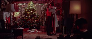 Movie still from “Blow” (2001), directed by Ted Demme – A man and a woman hugging in front of a christmas tree; Wide shot, Low angle