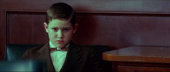 Movie still from “Blow” (2001), directed by Ted Demme – A boy in a suit and bow tie sitting at a table; Close Up shot, Low angle