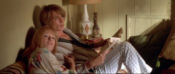 Movie still from “Blow” (2001), directed by Ted Demme – A woman and a little girl sitting on a couch; Medium shot, High angle
