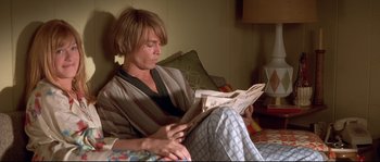 Movie still from “Blow” (2001), directed by Ted Demme – A man sitting on a couch reading a newspaper; Medium shot, High angle
