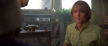 Movie still from “Blow” (2001), directed by Ted Demme – A man sitting in front of a table in a living room; Medium shot, Low angle