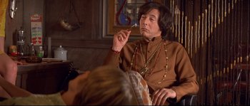 Movie still from “Blow” (2001), directed by Ted Demme – A man sitting in front of a woman smoking a cigarette; Medium shot, Low angle