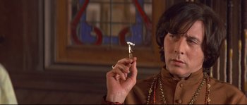 Movie still from “Blow” (2001), directed by Ted Demme – A woman smoking a cigarette in front of a stained glass window; Close Up shot, High angle