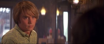 Movie still from “Blow” (2001), directed by Ted Demme – A young man with blonde hair and a yellow shirt; Close Up shot, Over the shoulder angle