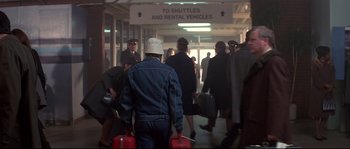 Movie still from “Blow” (2001), directed by Ted Demme – A group of people walking down a hall way with suitcases; Wide shot, Over the shoulder angle