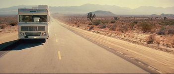 Movie still from “Blow” (2001), directed by Ted Demme – A road that has a lot of dirt on the side of the road; Extreme Wide shot, High angle