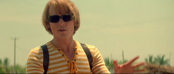 Movie still from “Blow” (2001), directed by Ted Demme – A woman wearing sunglasses and a striped shirt; Close Up shot, Low angle