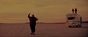 Movie still from “Blow” (2001), directed by Ted Demme – An overweight man standing in the middle of an open field; Wide shot, Low angle