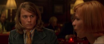 Movie still from “Blow” (2001), directed by Ted Demme – A man with long hair wearing a suit and tie; Close Up shot, Over the shoulder angle
