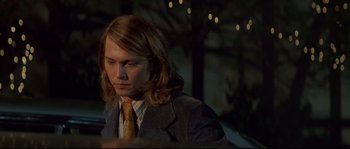 Movie still from “Blow” (2001), directed by Ted Demme – A man with long hair wearing a suit and tie; Close Up shot, Low angle