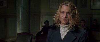 Movie still from “Blow” (2001), directed by Ted Demme – A man with long blonde hair wearing a white sweater; Close Up shot, Over the shoulder angle