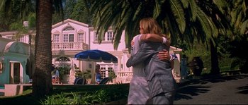 Movie still from “Blow” (2001), directed by Ted Demme – Two people hug in front of a large house; Wide shot, Low angle